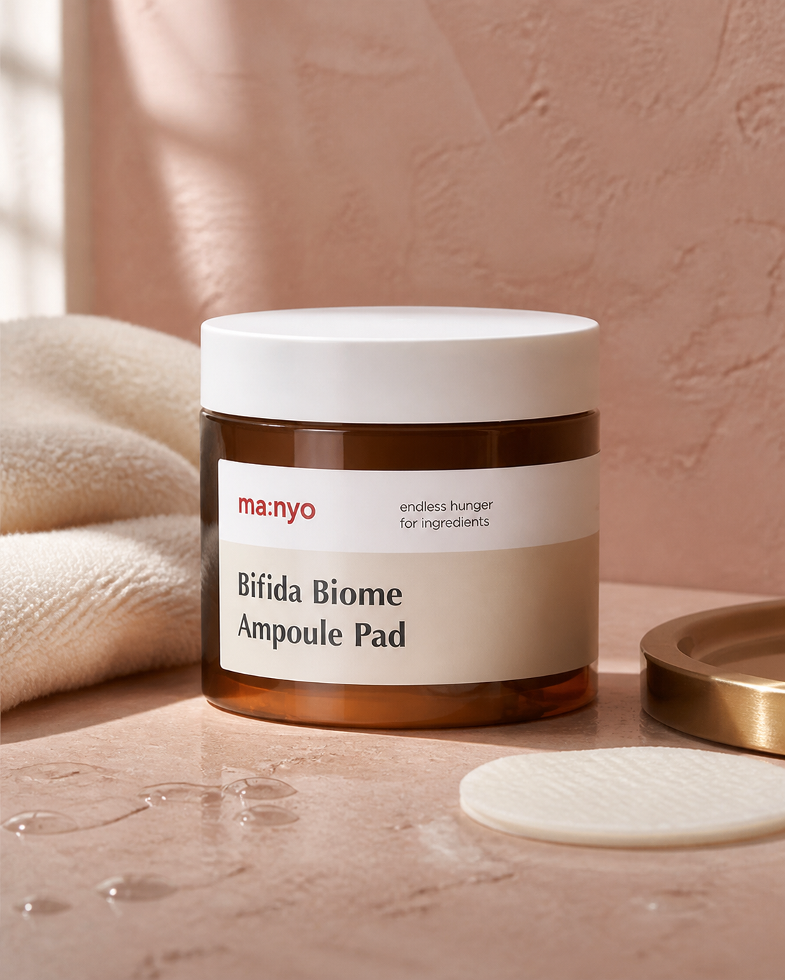 ma:nyo Bifida Biome Ampoule Pad jar with toner pad in a warm bathroom setting