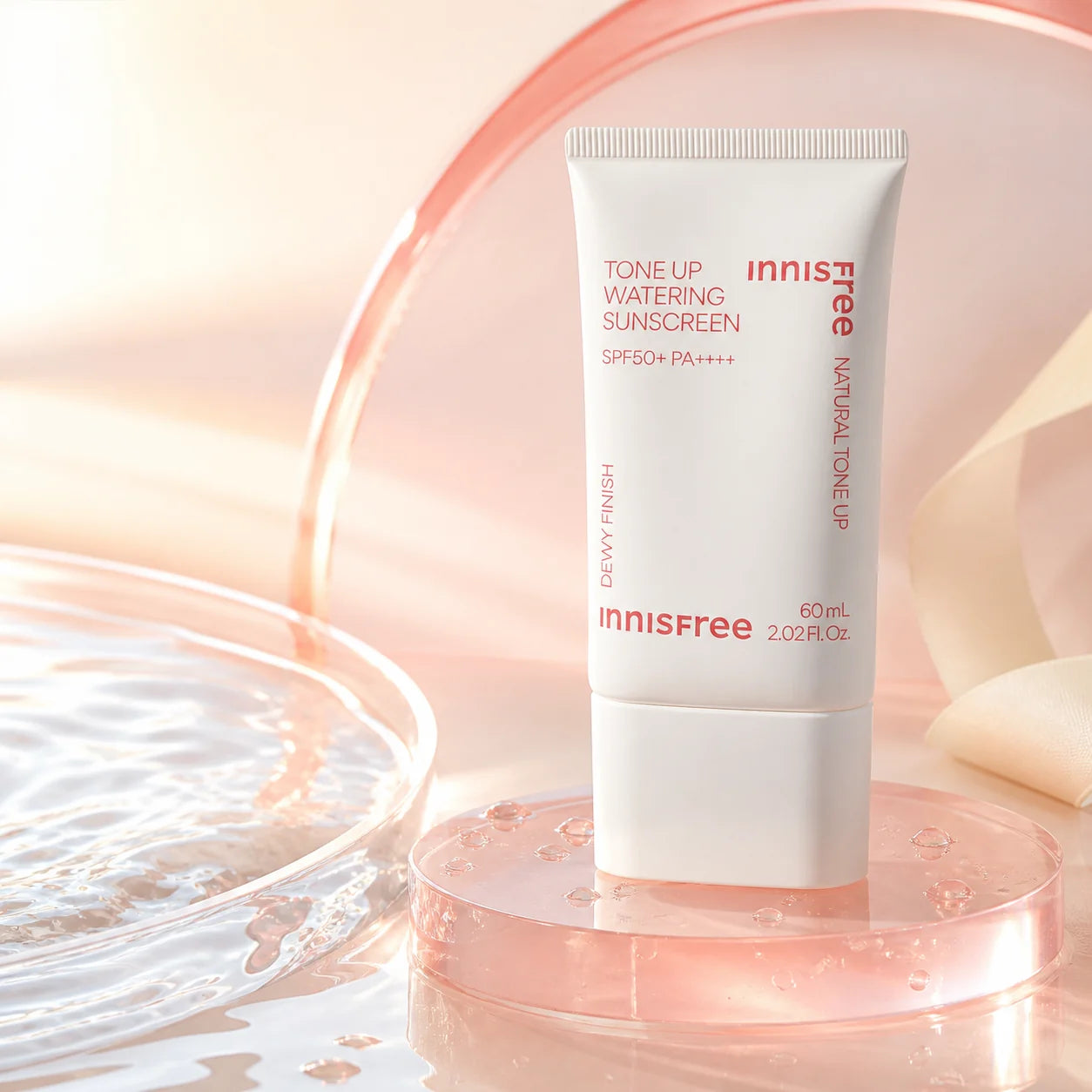 Innisfree Tone Up Watering Sunscreen SPF50+ PA++++ 60ml on a pink glass pedestal by water