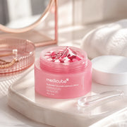 Open medicube PDRN Pink Collagen Capsule Cream jar with clear gel and pink capsules on a vanity
