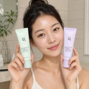 Woman holding Beauty of Joseon Stay Fresh Tone-Up Sunscreen Green and Purple tubes