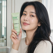 Woman holding Dr.FORHAIR Phyto Therapy Scalp Essence 80ml beside her face