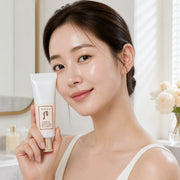 Woman holding The History of Whoo Radiant White Tone Up Sunscreen beside her face