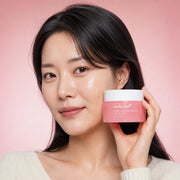 Woman holding medicube PDRN Pink Collagen Capsule Cream 55g beside her cheek