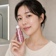 Woman holding medicube PDRN Pink Collagen Exosome Shot 2000 30ml beside her cheek
