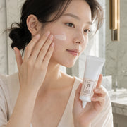 Woman applying The History of Whoo Radiant White Tone Up Sunscreen to her cheek