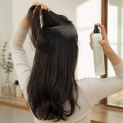 Woman applying CHAHONG Fix Volume Hair Spray to a lifted back section from a safe distance