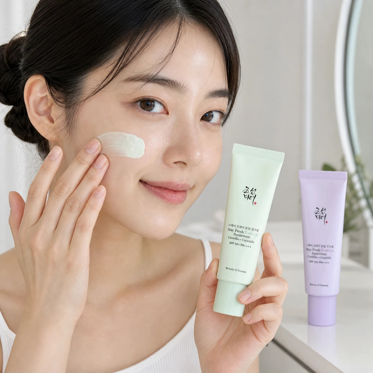 Woman applying Beauty of Joseon Green Tone-Up Sunscreen to her cheek