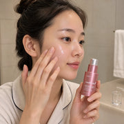 Woman pressing medicube PDRN Pink Collagen Exosome Shot 2000 serum onto her outer cheek