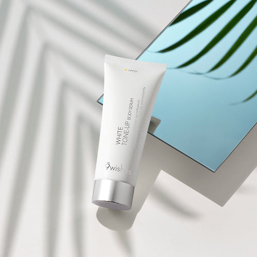 9wishes White Tone-Up Body Serum SPF21 150ml tube beside a mirror in sunlight