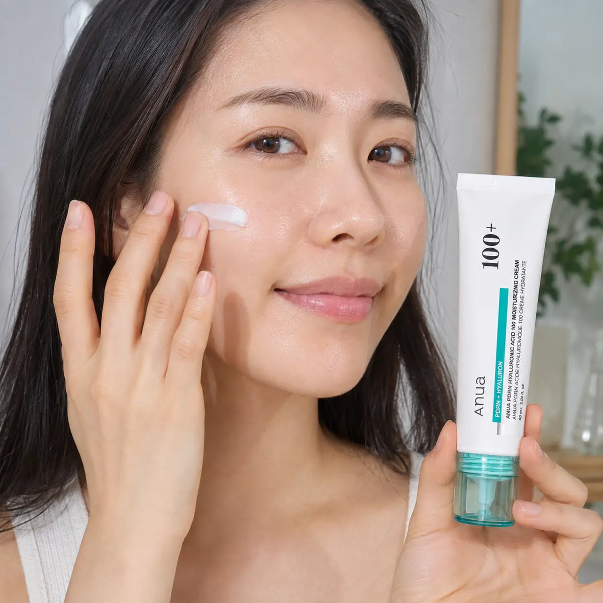 Applying ANUA PDRN Hyaluronic Acid 100 Moisturizing Cream to the cheek