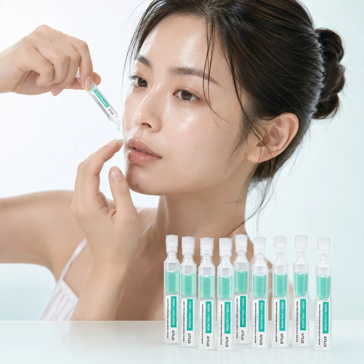 Applying one Anua PDRN Hyaluronic Acid serum capsule to the cheek