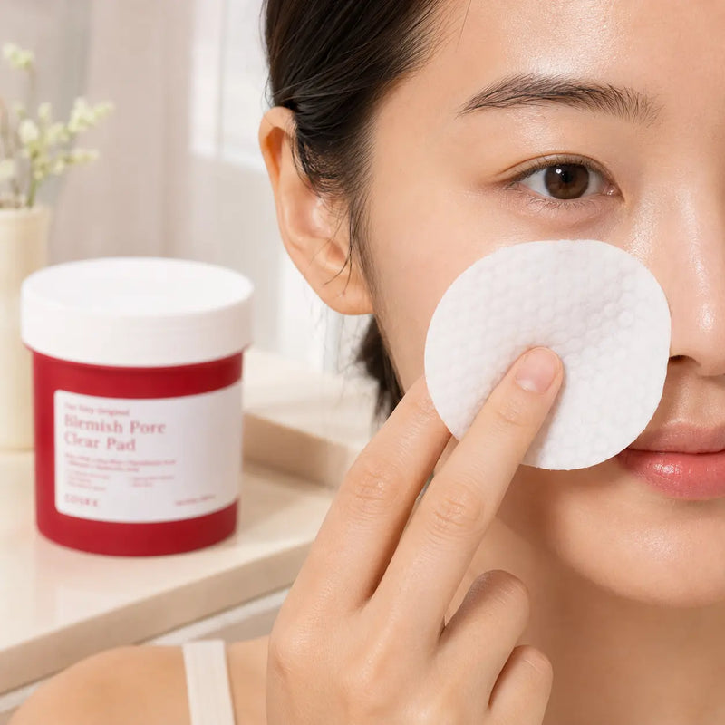 Woman gently sweeping a COSRX Blemish Pore Clear Pad across the side of her nose and cheek