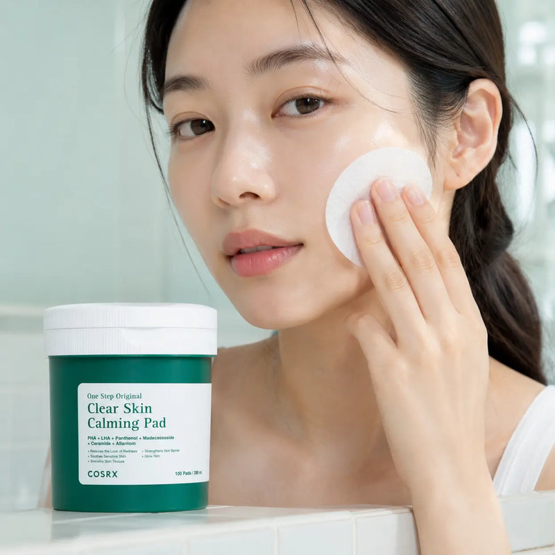 Gently pressing COSRX Clear Skin Calming Pad onto the cheek