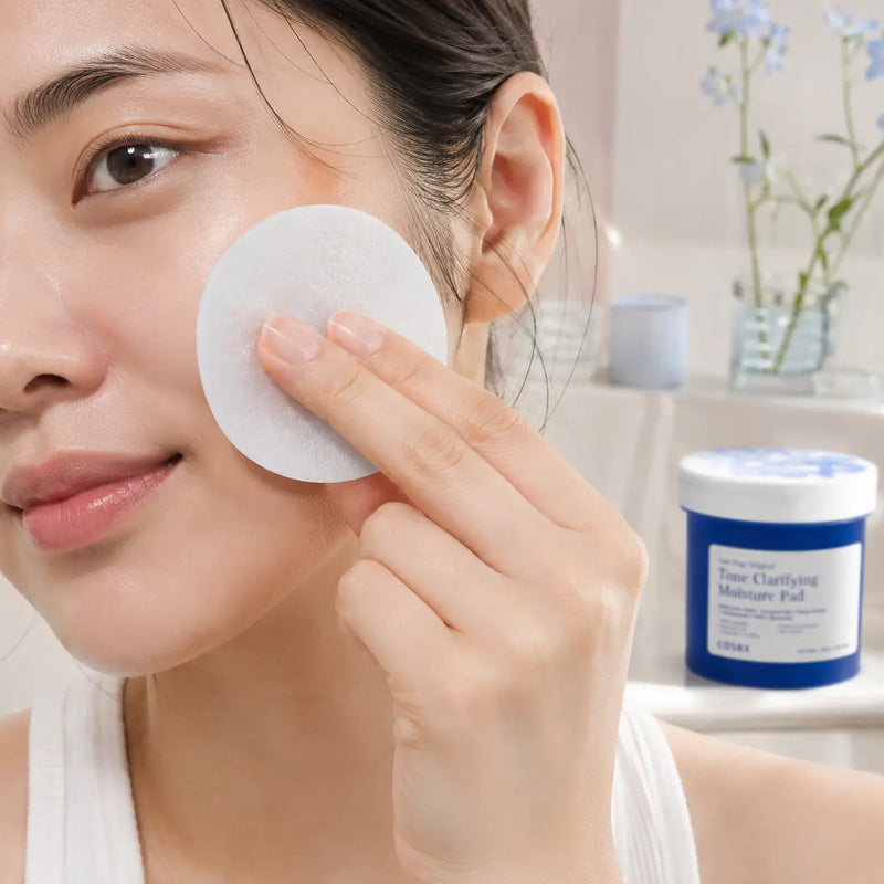 Applying COSRX Tone Clarifying Moisture Pad gently to the cheek