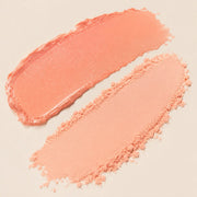 Macro swatches of Fair Lady pale peach shimmer balm and coral nude beige powder textures