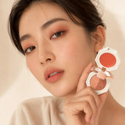 Model wearing a warm rose bronze eye look and holding the Sunset Romance palette