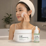 Woman gently using a Dr.AG+ Cica Repair Peeling Pad in an evening skincare routine