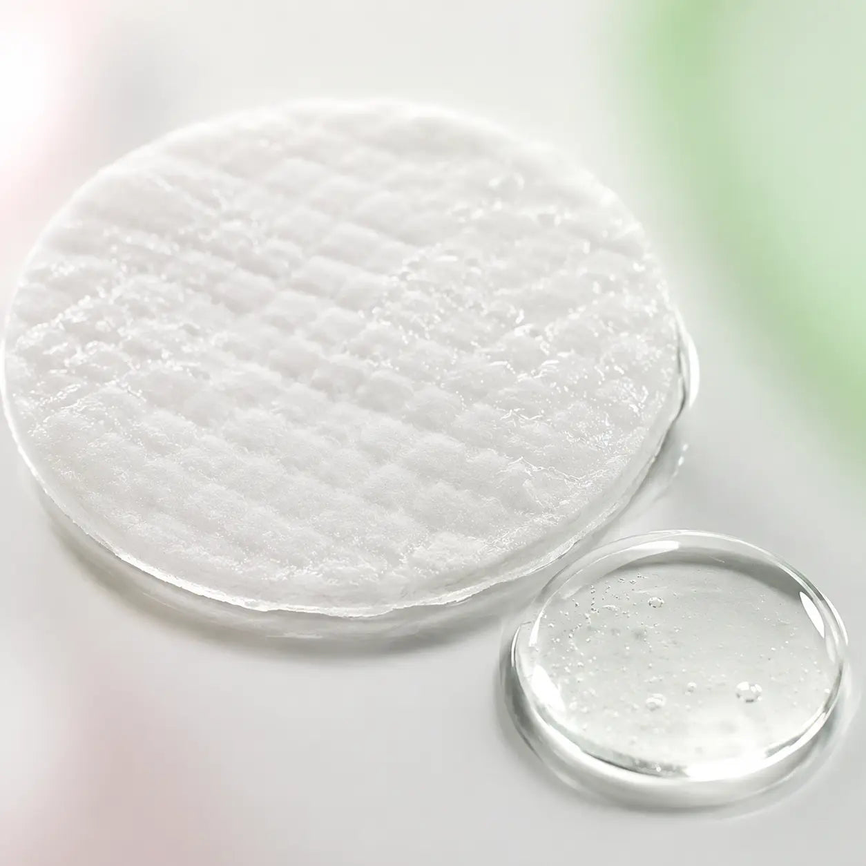 Macro of an essence soaked embossed peeling pad and clear cica hyaluronic ampoule texture