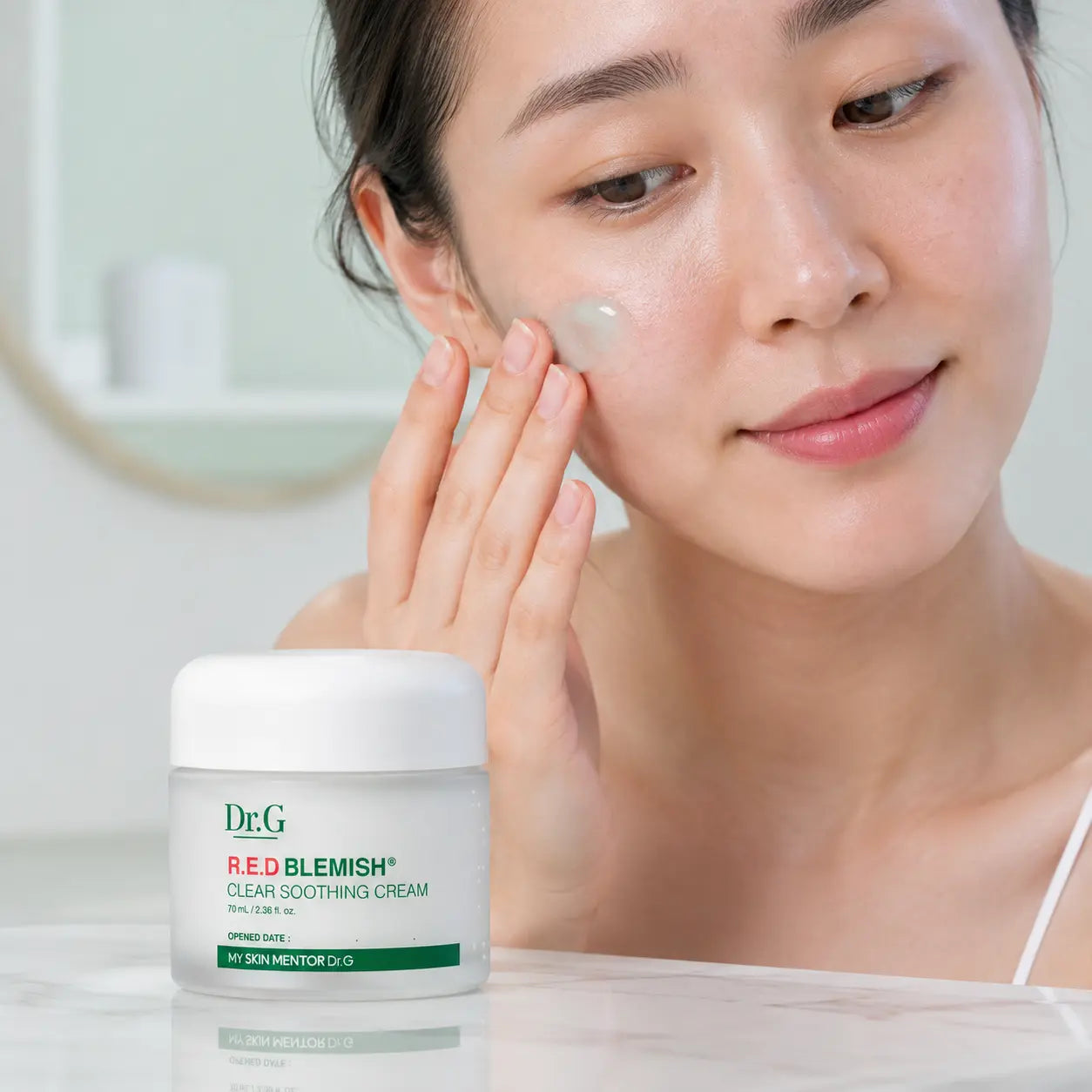 Applying Dr.G R.E.D Blemish Clear Soothing Cream to the cheek