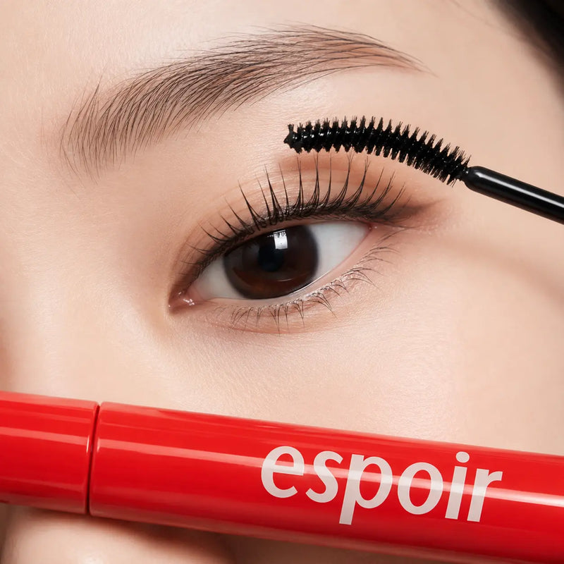 Applying espoir Nomudging Mascara Clean Black to upper lashes