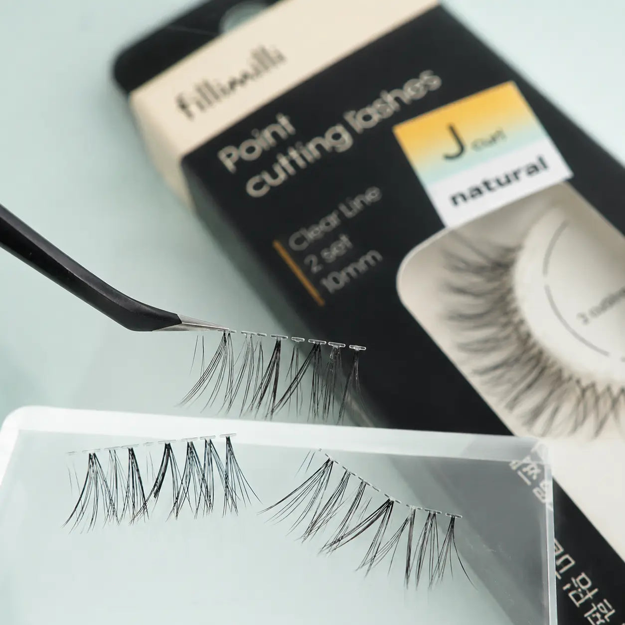 Close-up of Fillimilli Natural J Curl lash sections and clear band