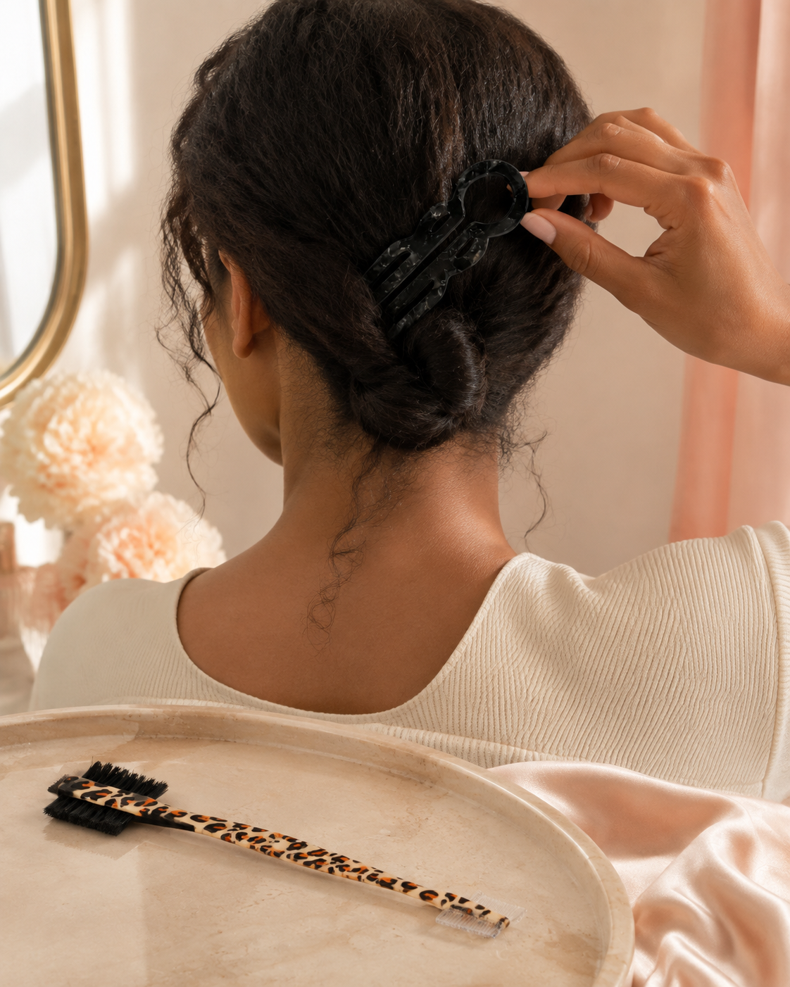 Black marbled hair pin securing a low twist with leopard edge brush nearby