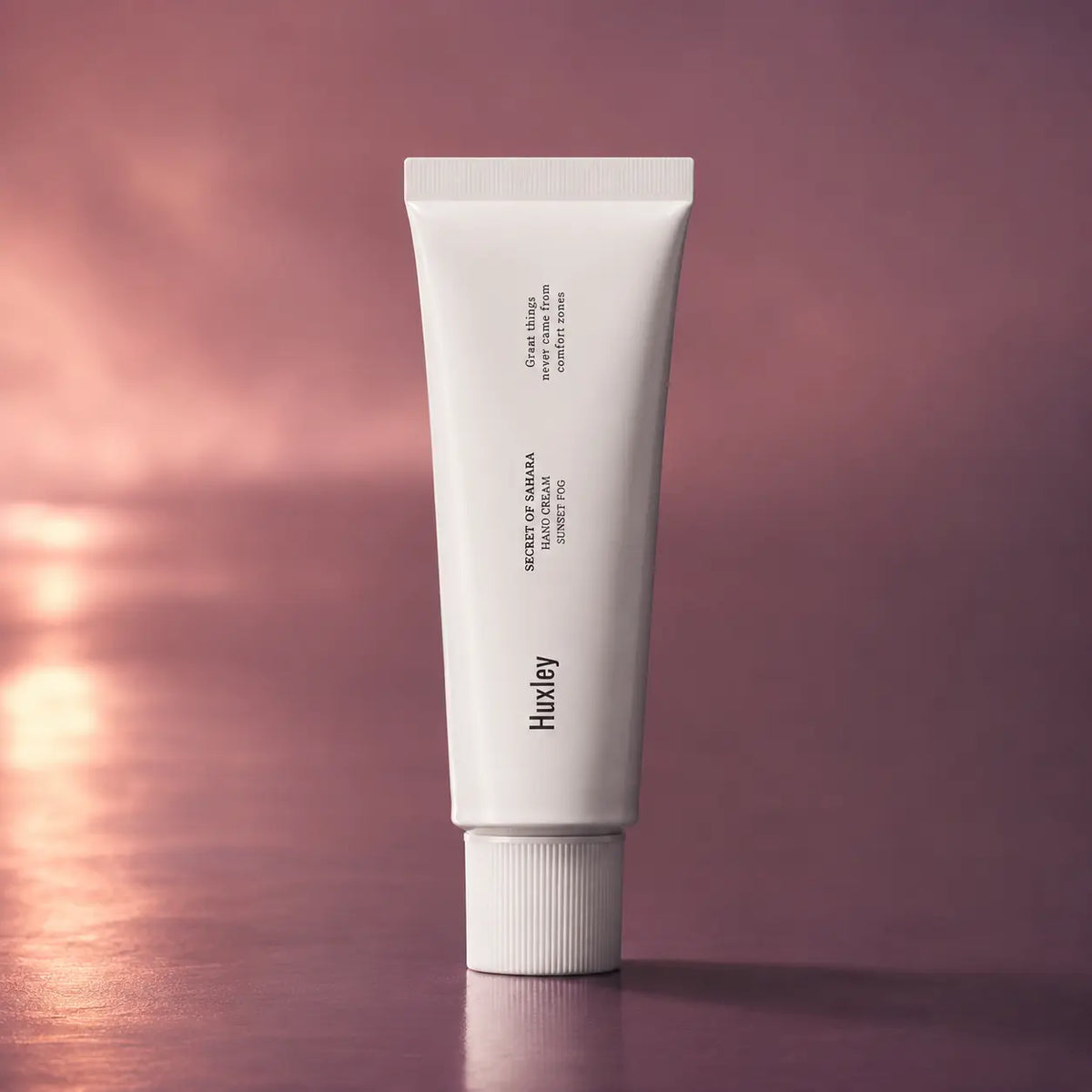 Huxley Hand Cream Sunset Fog 30 ml tube on a mauve sunset background