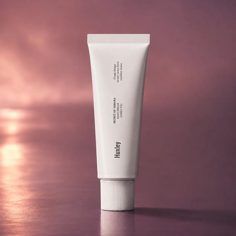 Huxley Hand Cream Sunset Fog 30 ml tube on a mauve sunset background