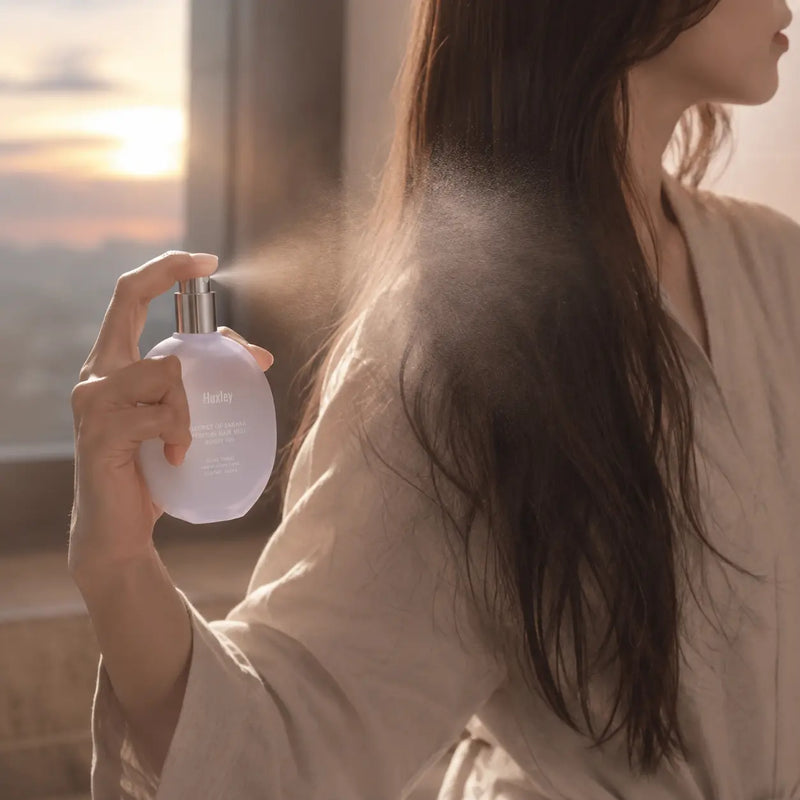 Huxley Sunset Fog hair mist sprayed over the mid-lengths of hair