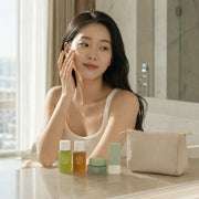 Woman applying KAINE Green Calm Aqua Cream with the travel kit