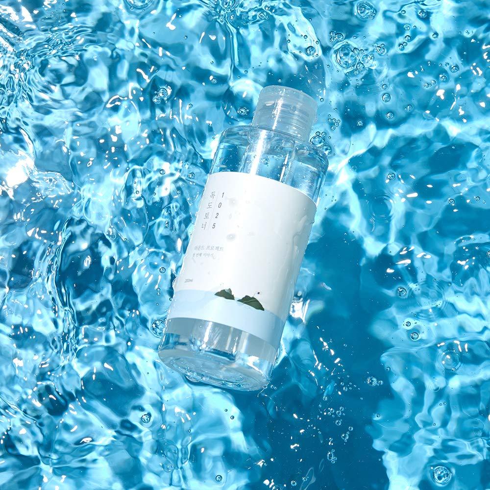 ProtoClinical k-beauty Round Lab 1025 Dokdo Toner 200ml aqua product silhouette with a bright center on a blue background.