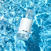 ProtoClinical k-beauty Round Lab 1025 Dokdo Toner 200ml aqua product silhouette with a bright center on a blue background.