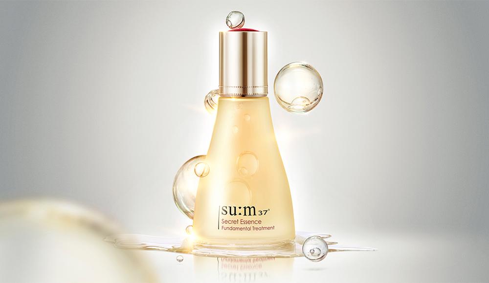 ProtoClinical k-beauty su:m37 Secret Essence 80ml product packaging with blue-gray side shading on a light background.