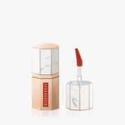 ProtoClinical k-beauty [DEAR DAHLIA] Paradise Dream Velvet Lip Mousse 6.5ml #03 October close-up with a centered vertical package form, soft beige and muted coral tones, and a pale background