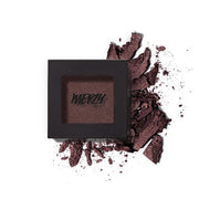 ProtoClinical k-beauty MERZY THE FIRST EYESHADOW 2g (5 Colors) single square black compact with a deep plum-brown shadow pan, set over scattered crushed powder on a white background