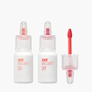 ProtoClinical k-beauty peripera Ink Airy Velvet 4g (NEW #35~#39) two upright lip tint package silhouettes with a slim peach tube beside a taller brown rectangular box on a pale blue and white background