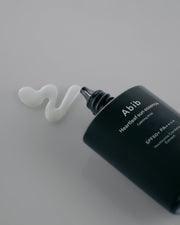 ProtoClinical k-beauty Abib Heartleaf sun essence Calming drop 50ml (SPF50+ PA++++) single upright dark sun essence package centered on a light background.