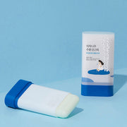 ProtoClinical k-beauty Round Lab Birch Juice Moisturizing Sun Stick 19g (SPF 50+ PA++++) open white sun stick lying beside its upright package on a light blue background