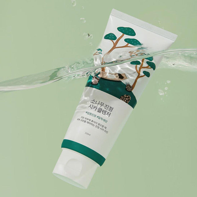 ProtoClinical k-beauty Round Lab Pine Calming Cica Cleanser 150ml single white cleanser tube tilted under a clear water splash on a pale green background