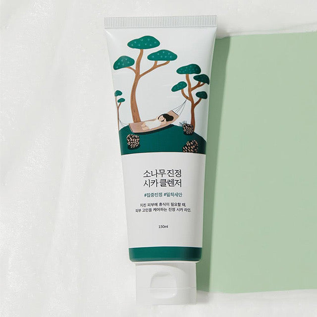 ProtoClinical k-beauty Round Lab Pine Calming Cica Cleanser 150ml single white cleanser tube lying flat beside a mint green panel on a textured white background