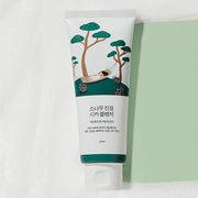 ProtoClinical k-beauty Round Lab Pine Calming Cica Cleanser 150ml single white cleanser tube lying flat beside a mint green panel on a textured white background