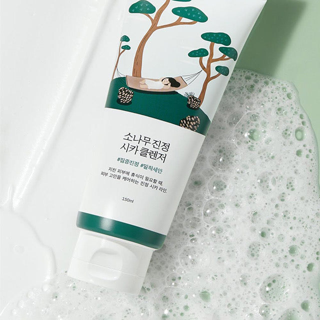 ProtoClinical k-beauty Round Lab Pine Calming Cica Cleanser 150ml single white cleanser tube resting diagonally beside foamy bubbles on a pale green background