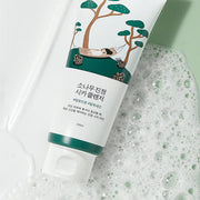 ProtoClinical k-beauty Round Lab Pine Calming Cica Cleanser 150ml single white cleanser tube resting diagonally beside foamy bubbles on a pale green background