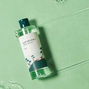 ProtoClinical k-beauty Round Lab Pine Calming Cica Toner 250ml packaging silhouette with a soft blue vertical center on a warm beige background.