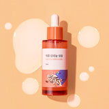 ProtoClinical k-beauty Round Lab Soybean Panthenol Ampoule 50ml single upright amber ampoule bottle centered on a warm beige background with soft cream side panels.
