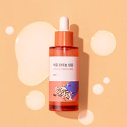 ProtoClinical k-beauty Round Lab Soybean Panthenol Ampoule 50ml single upright amber ampoule bottle centered on a warm beige background with soft cream side panels.