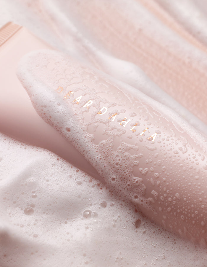 ProtoClinical k-beauty DEAR DAHLIA Heavenly Facial Cleanser warm beige beauty close-up with deep brown shading and soft pink tones.