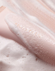 ProtoClinical k-beauty DEAR DAHLIA Heavenly Facial Cleanser warm beige beauty close-up with deep brown shading and soft pink tones.