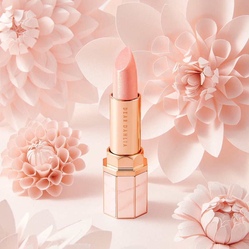 ProtoClinical k-beauty DEAR DAHLIA Paradise Tinted Blooming Balm close-up of soft beige product packaging with muted taupe panels on a light background