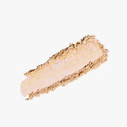ProtoClinical k-beauty DEAR DAHLIA Skin Luminous Highlighter shown as a warm beige highlighter swatch spread horizontally on a light background